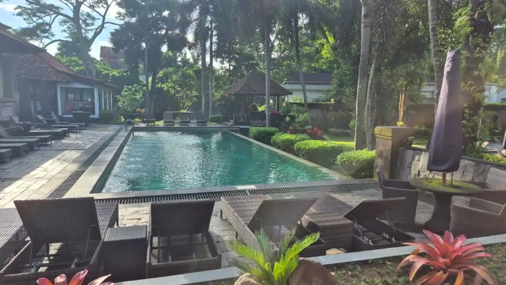 Kolam renang luar ruangan yang asri dikelilingi pepohonan tropis di Champlung Sari Hotel Ubud